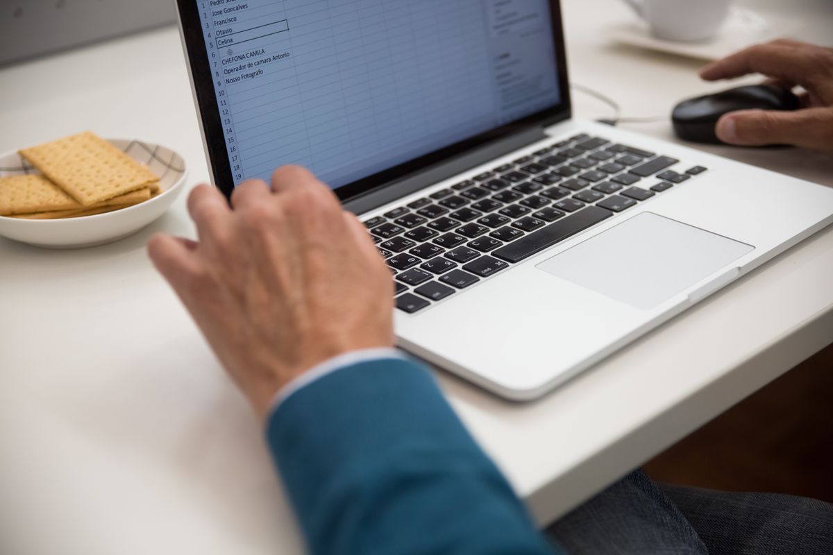 Trader reviewing a spreadsheet trade log on a laptop to audit swing trading mistakes in position sizing and order execution